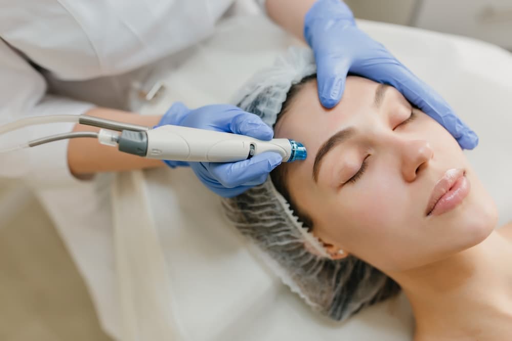 Patient receiving a device-based facial skin treatment in a clinic